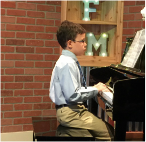Young Boy playing the Piano in recital